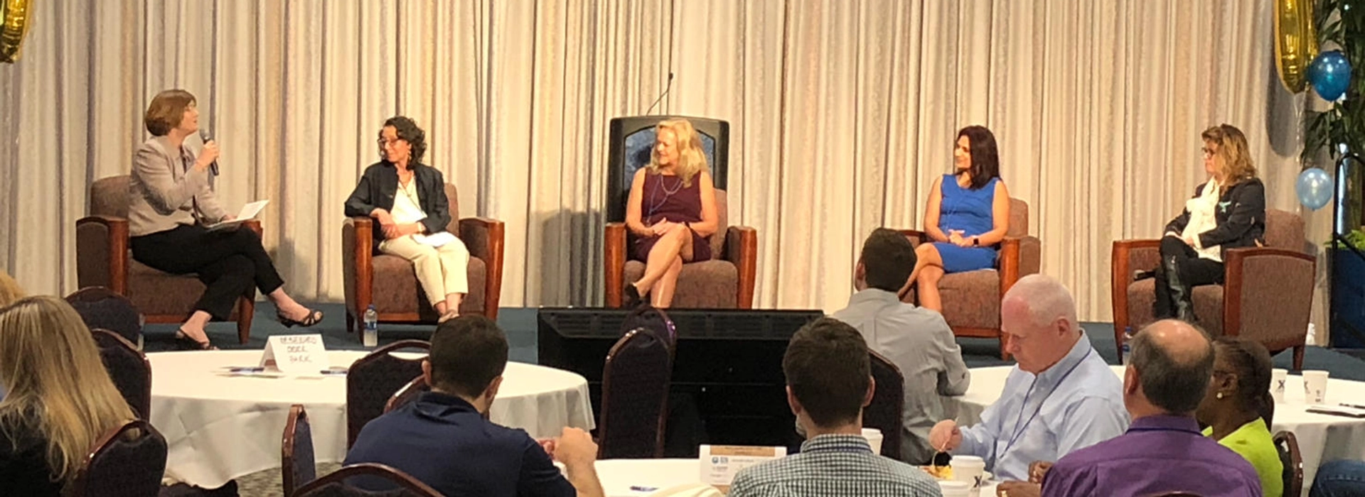 A photo of an expert panel on stage discussing Digital Transformation.