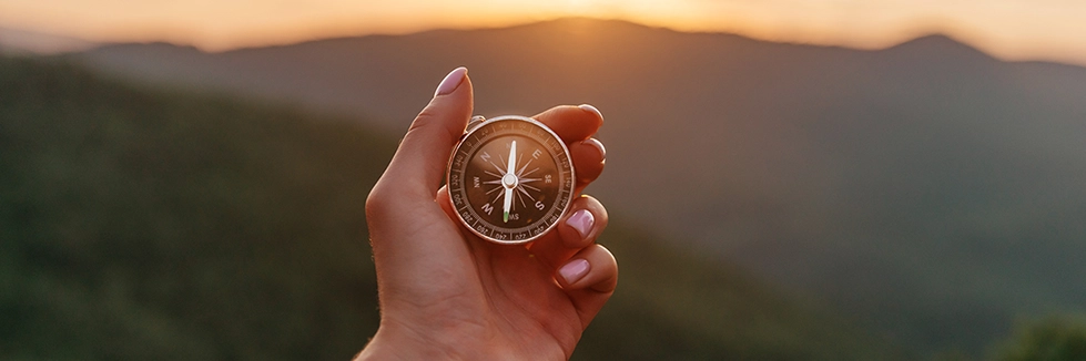 A hand holding a compass to represent Navigating Change services provided by Ayuka Consulting.