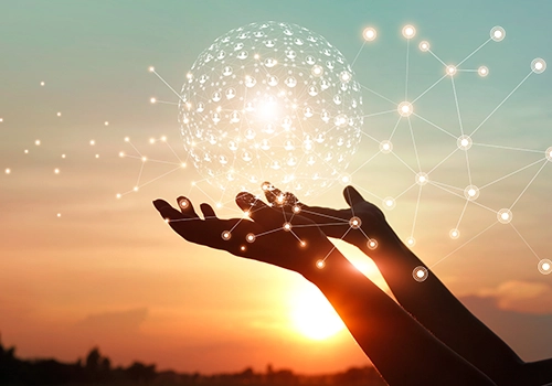 An image of hands held up open to a digital ball of user icons in front of a sunrise to represent organizational change management.